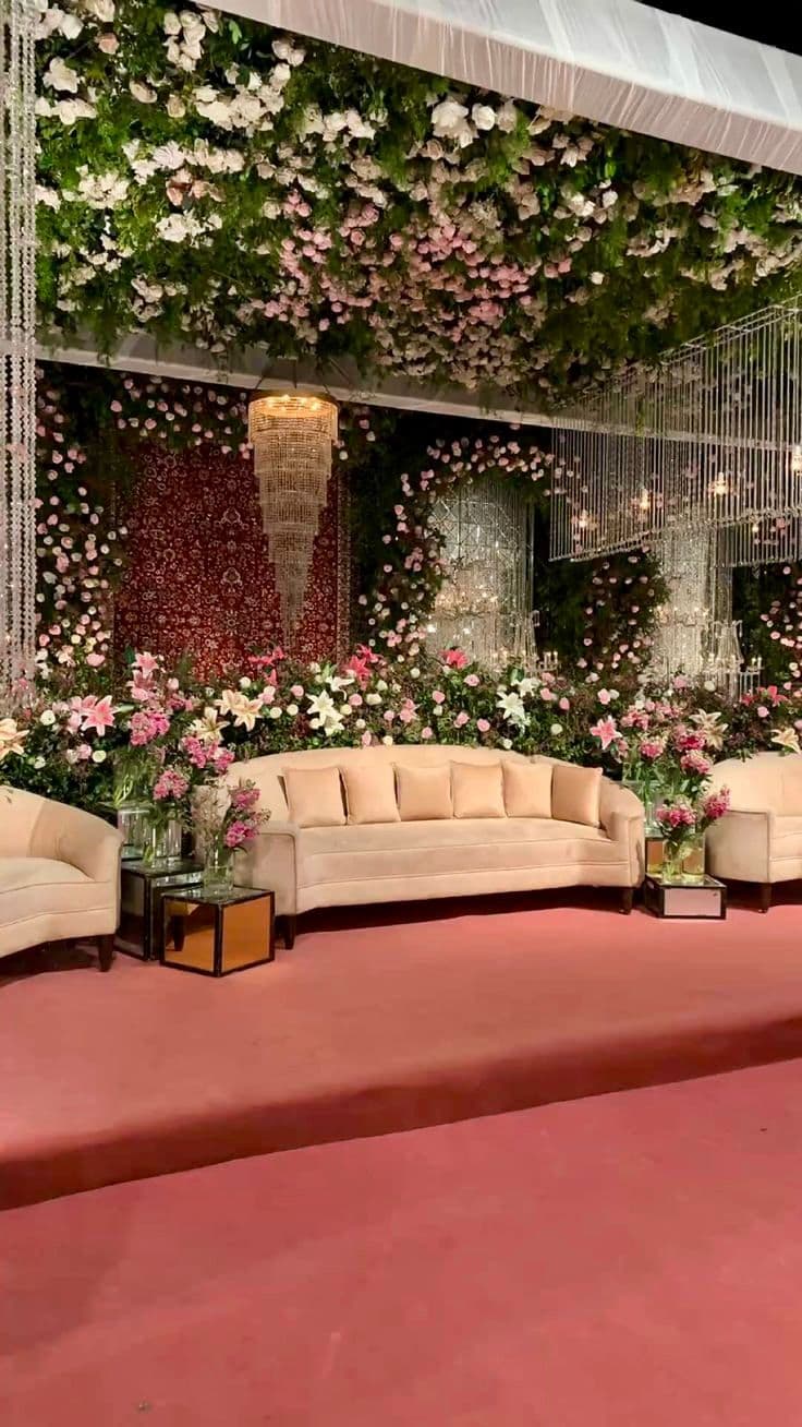 An elegant wedding stage featuring an arrangement of colorful flowers and abundant greenery.