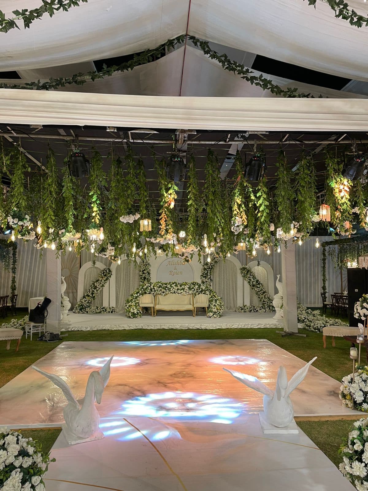 A beautifully arranged wedding reception featuring elegant white flowers and lush greenery throughout the venue.
