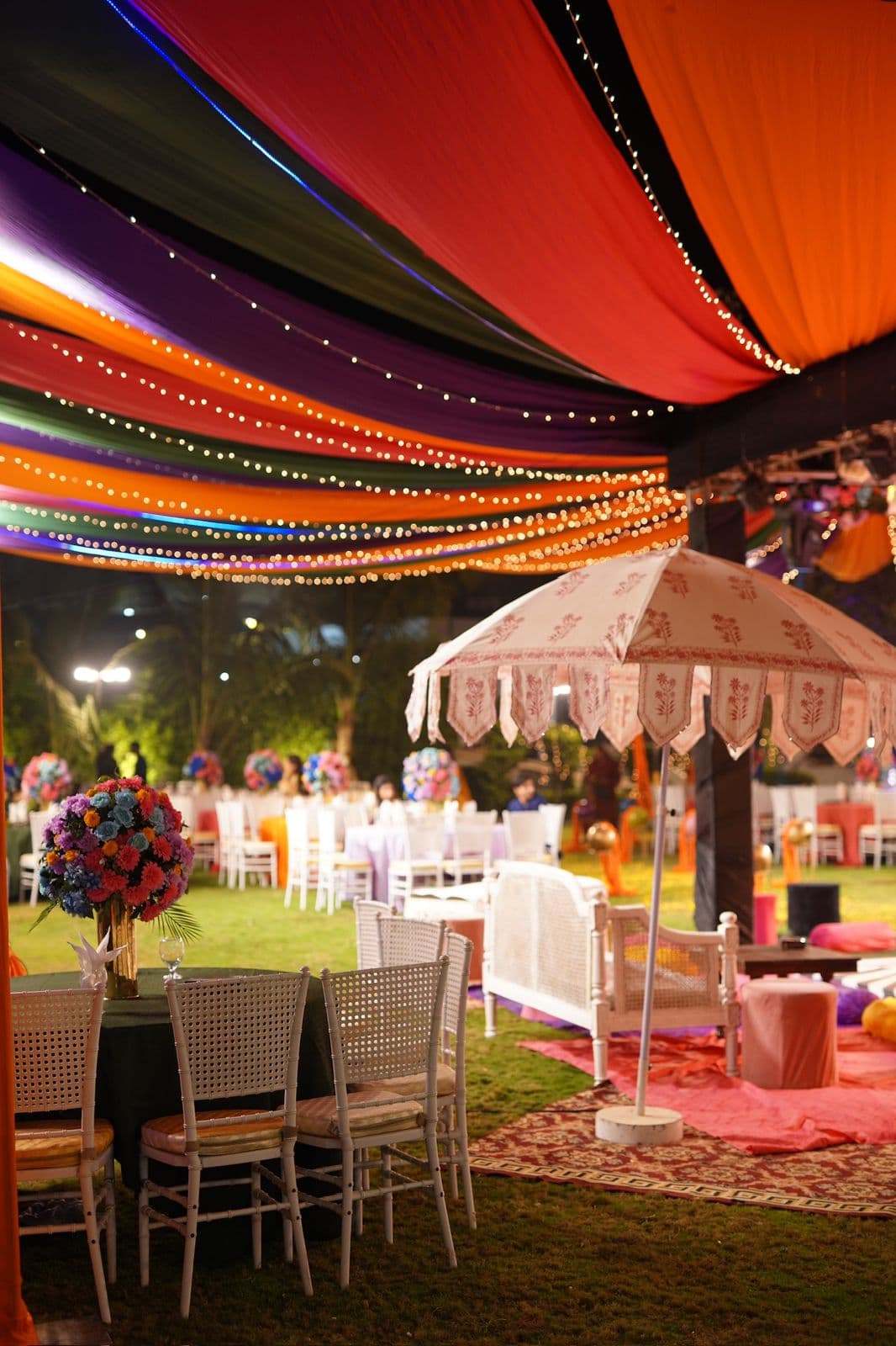 A colorful tent with neatly arranged tables and chairs beneath a canopy, providing a cheerful atmosphere for socializing.