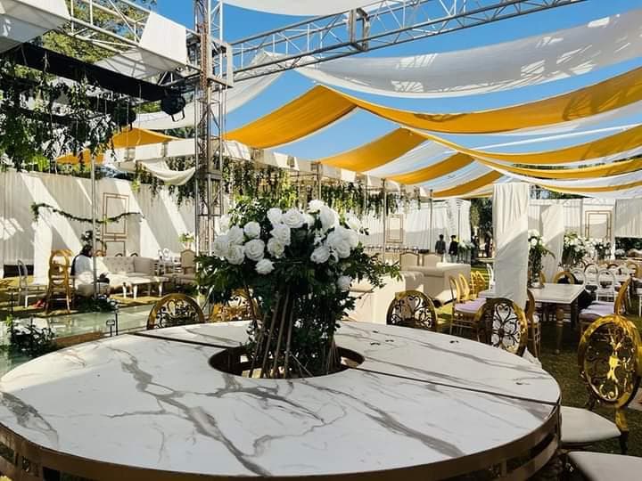 A white table adorned with elegant yellow and gold drapes, creating a vibrant and sophisticated atmosphere.