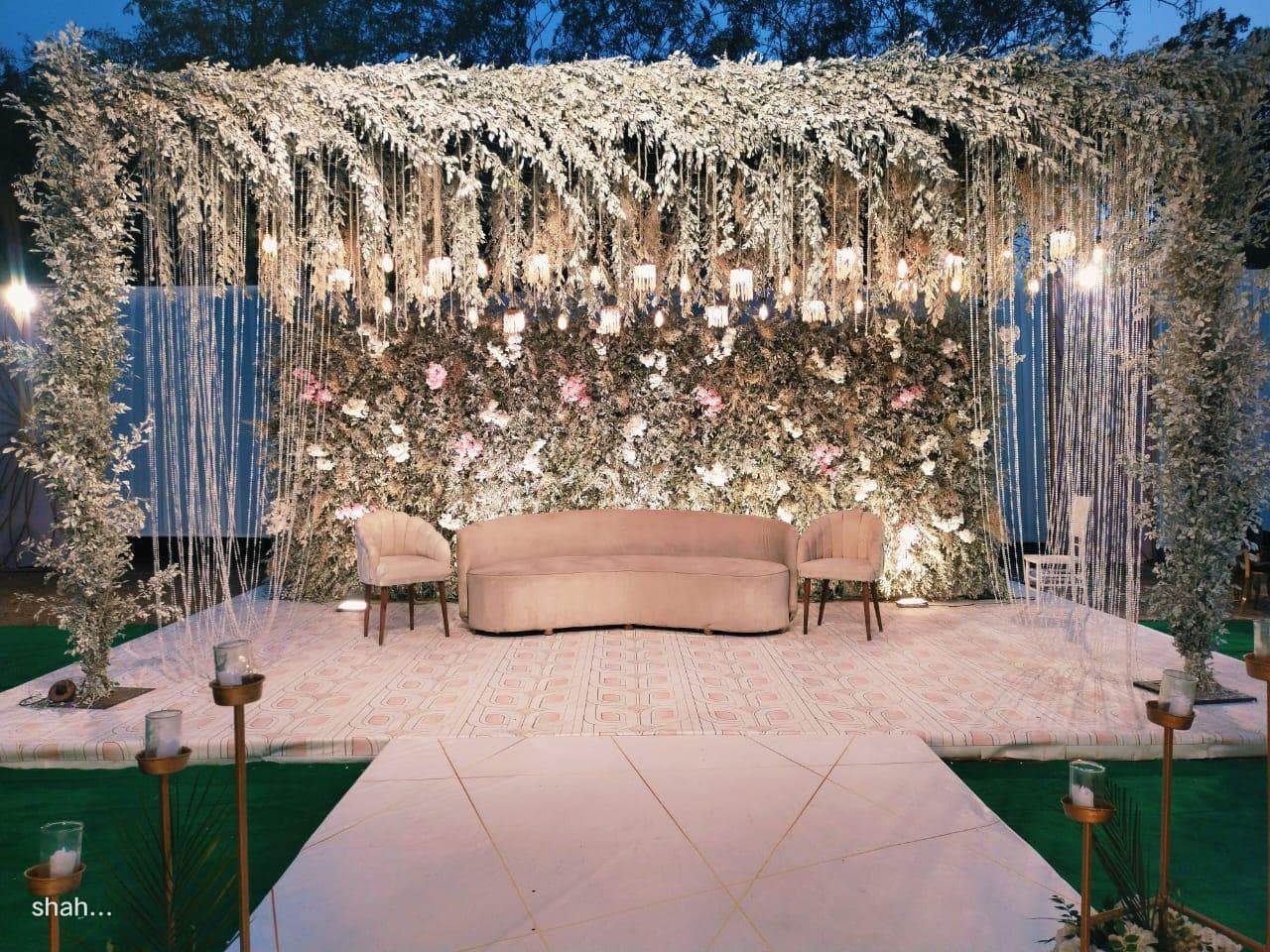 A wedding stage adorned with vibrant flowers and lush greenery, creating a romantic and elegant atmosphere.