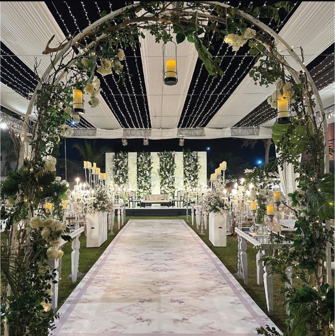 A wedding ceremony featuring elegant white and green decor, with floral arrangements and a beautifully set altar.