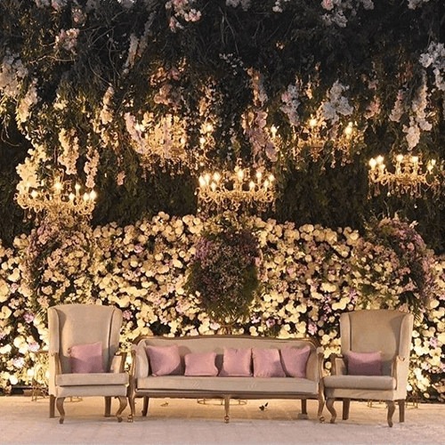 An enchanting wedding stage embellished with vibrant purple and white flowers, setting a charming backdrop for the ceremony.
