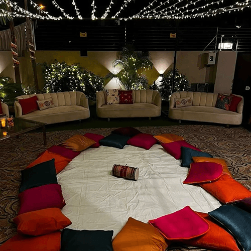 A spacious room filled with vibrant pillows and decorative lights, creating a cozy and inviting atmosphere.